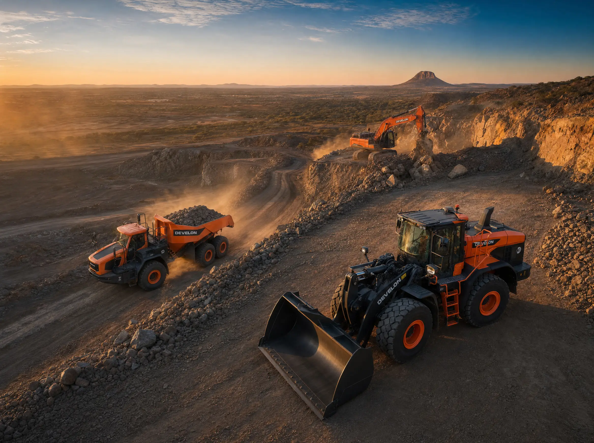 Oblique aerial of the DEVELON fleet working across a mine site at last light