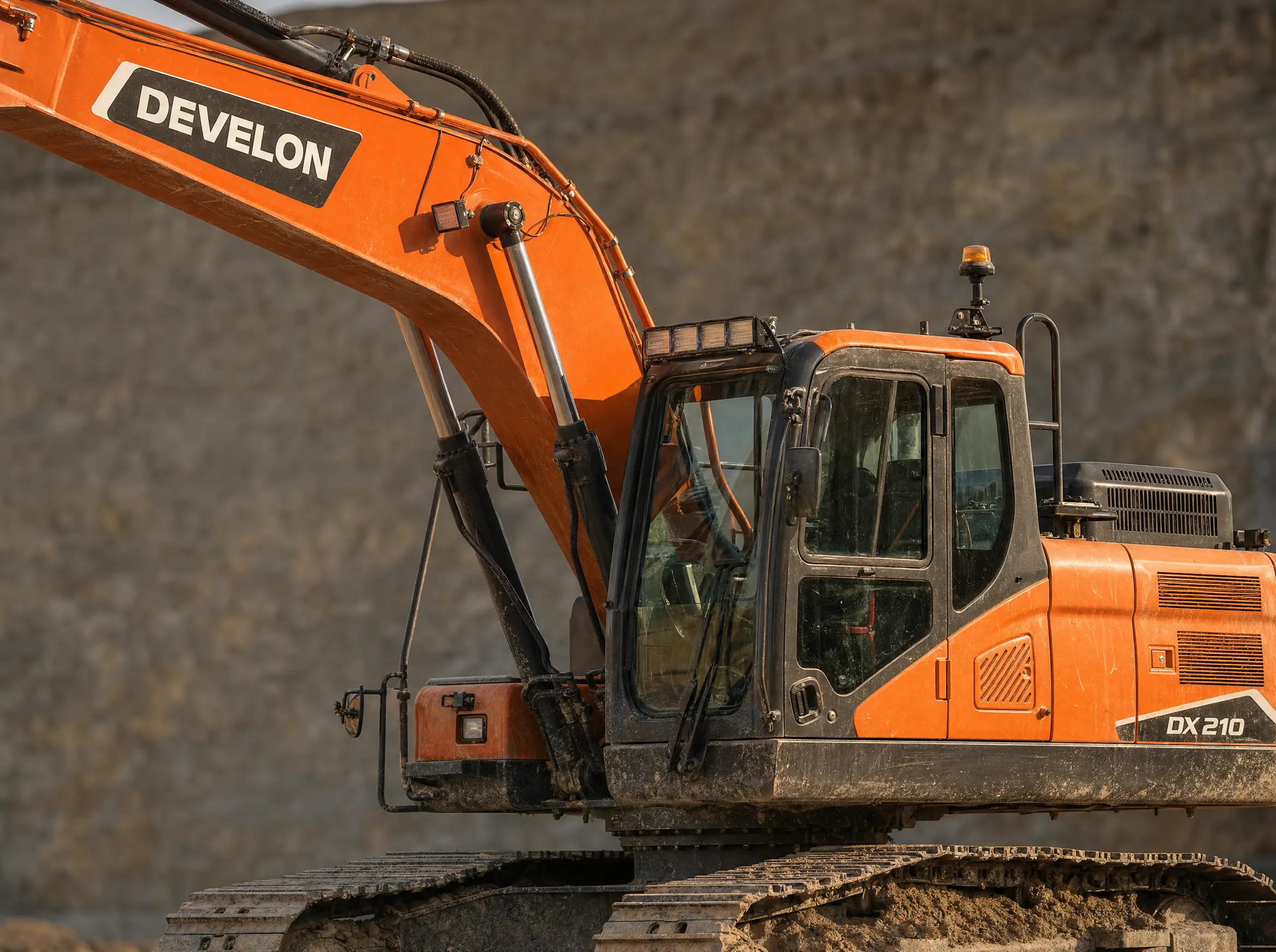 A close detail of a dusty DEVELON DX210 excavator, wordmark and model badge crisp
